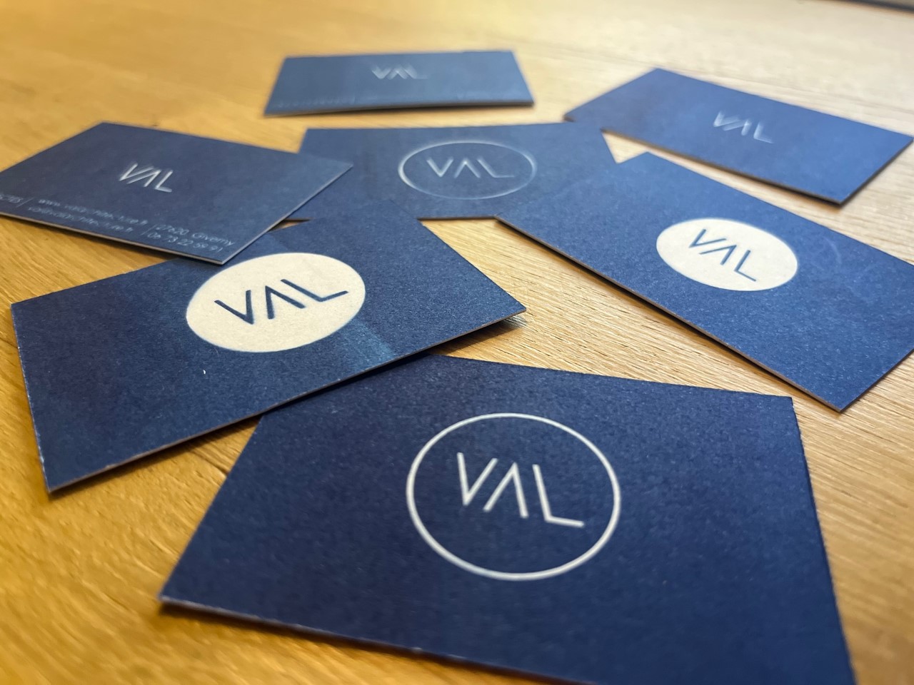 Cartes de visite de VAL Architecture sur une table en bois